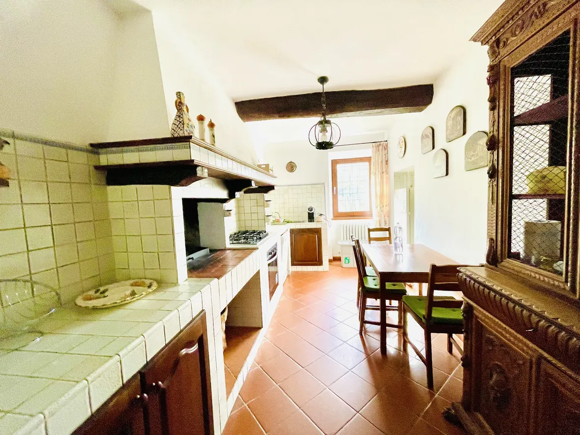 La cucina con le piastrelle verdi e il piano in muratura